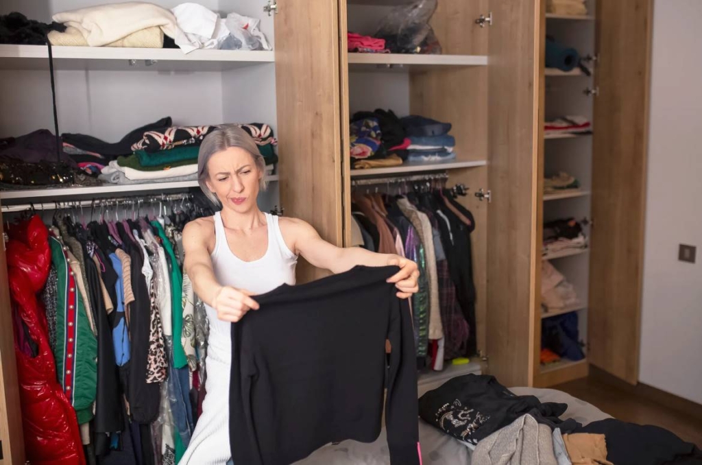 Donna che sceglie abiti per decluttering