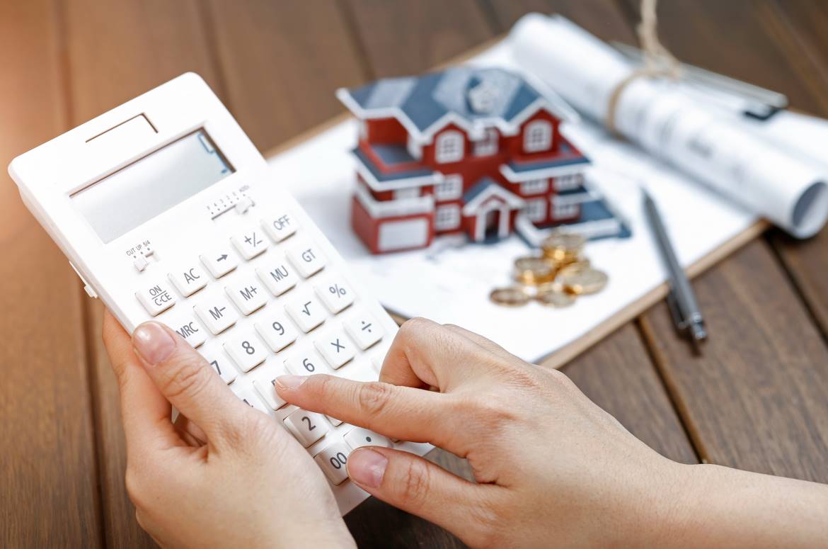 Donna con calcolatrice che calcola il valore della sua casa