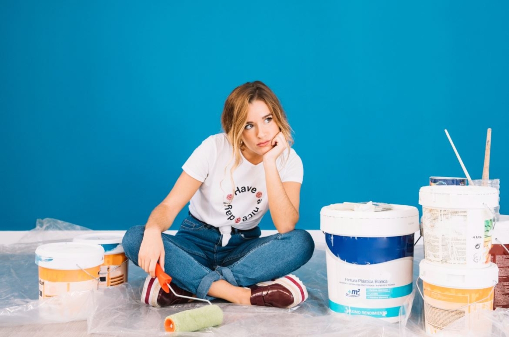 Ragazza che tinteggia parete - Come usare la psicologia del colore per vendere casa