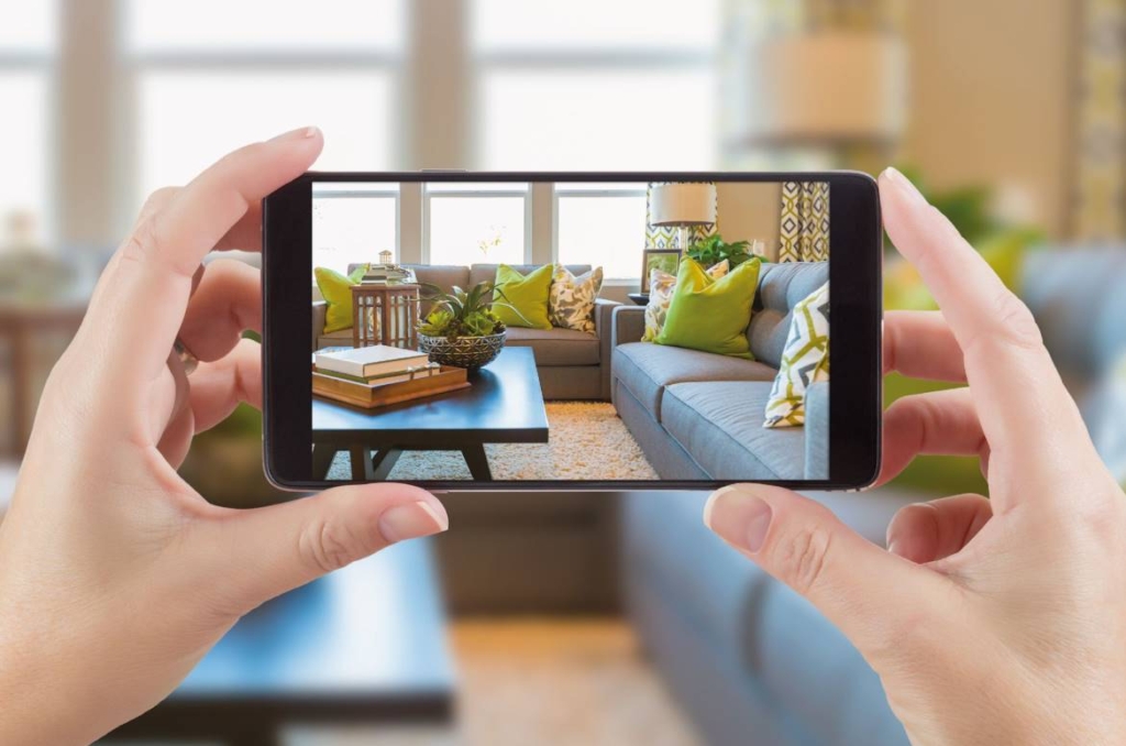 Fotografare casa - Mani di donna che scatta fotografie di interni con smartphone