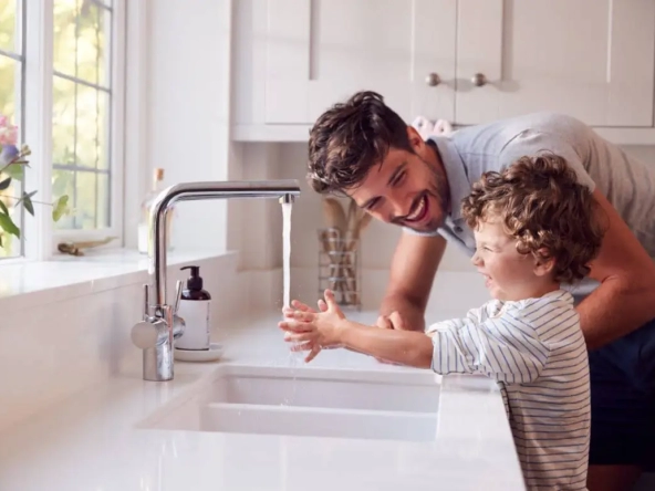 Come risparmiare su bolletta acqua - Immagine di giovane padre e figlio piccolo mentre si lava le mani