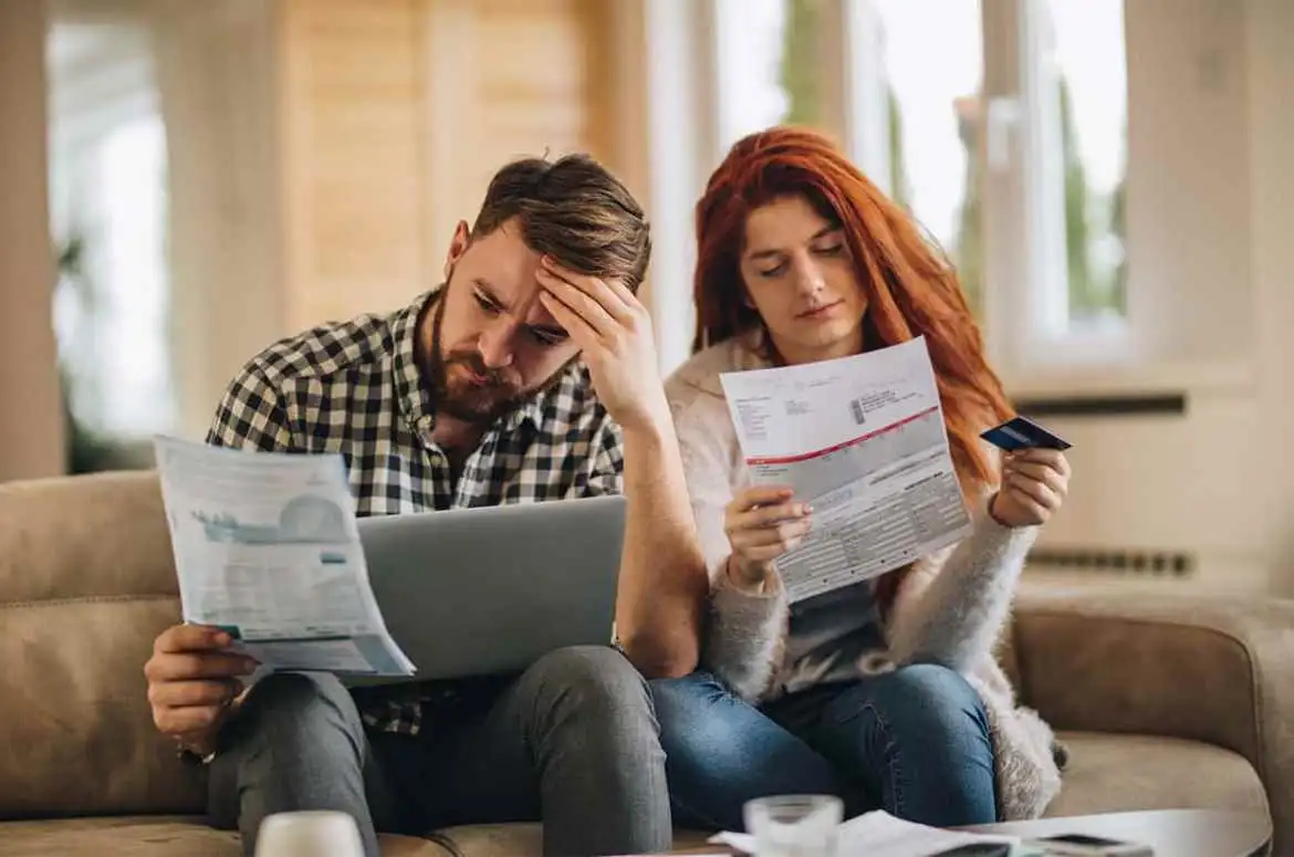 Come abbassare la bolletta - coppia che legge preoccupata la bolletta